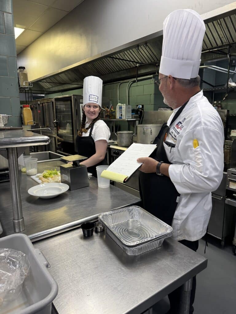 A student talking to Chef Greg in the Kids U Chef cooking camp.